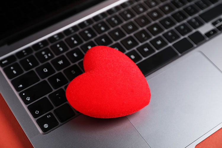 Piros szív egy laptop billentyűzetén – online társkeresés és a szerelem jelei